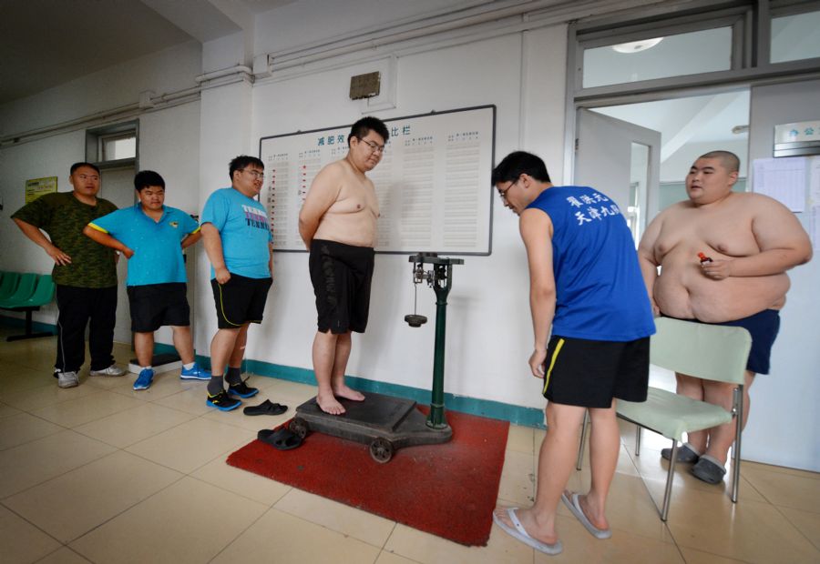 Na cidade portuária de Tiankin pessoas com excesso de peso fazem acupuntura e exercícios para redução de peso / MARK RALSTON / AFP