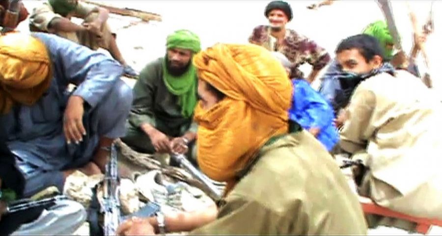 Militantes islâmicos sentam no chão com suas armas depois de destruir um antigo santuário em Timbuktu / STR / AFP