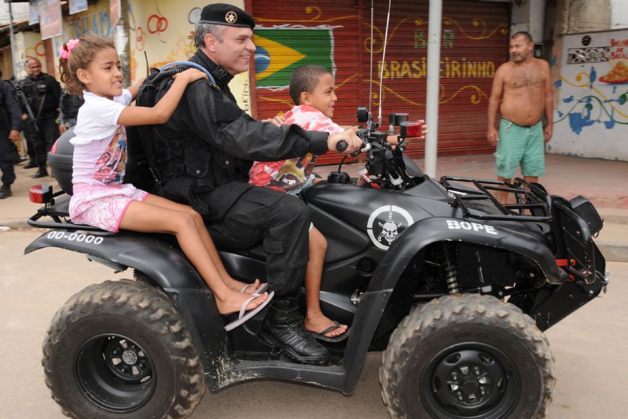 Agentes do Bope brincam com crianças após ocupação de favelas nos Complexos de Manguinhos e Jacarezinho, no Rio, em outubro / Sandro Vox/Folhapress