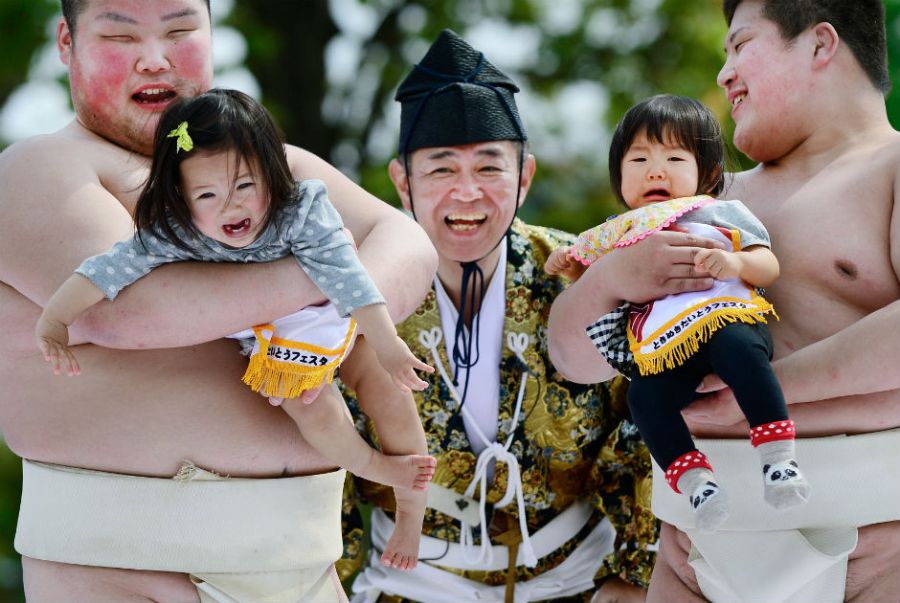  No evento, lutadores de sumô seguram bebês para começar a disputa