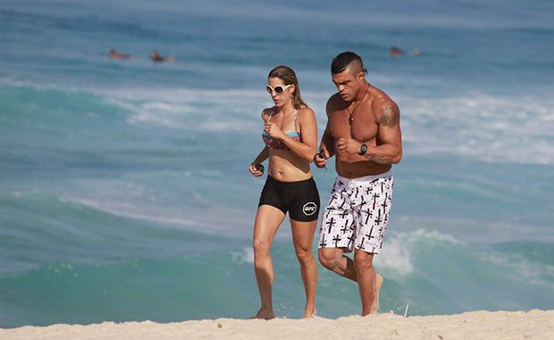 Joana Prado treina com marido em praia carioca