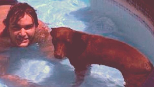 Ronald Rios com um de seus cachorros na piscina