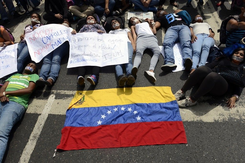 Estudantes deitaram no chão em protesto contra morte de estudante nas manifestações contra Maduro / Leo Ramirez /AFP