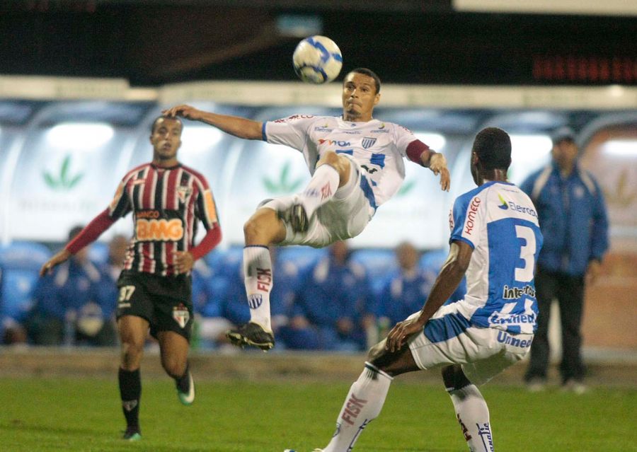 Emerson, do Avaí, salta para afastar a bola, observado por Lucas, do São Paulo (E)