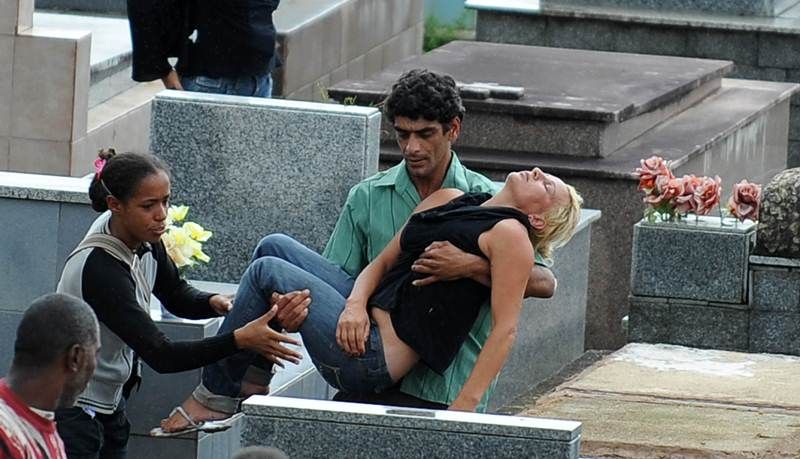 Mulher desmaia durante o enterro de parente vítima dos deslizamentos, no cemitério de Teresópolis