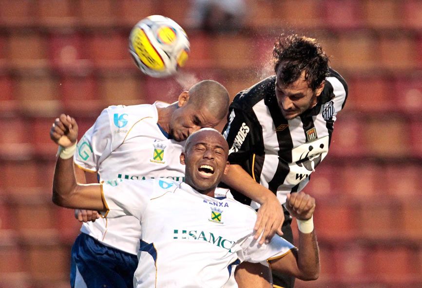 Edu Dracena disputa bola no alto contra dois do Santo André