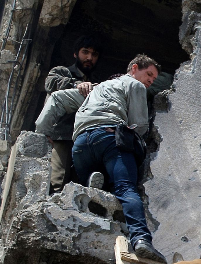 Foto mostra o jornalista Tim Hetherington recebendo ajuda de um rebelde líbio momentos antes de ser morto 