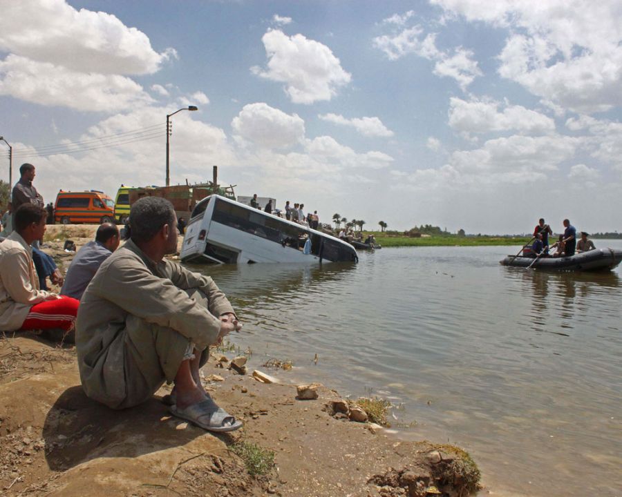 Egípcios olham para o mini-ônibus que afundou no Rio Nilo