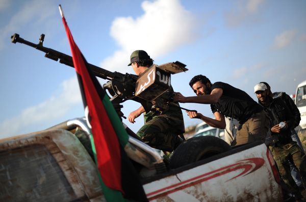 Homens recarregam uma metralhadora durante uma reunião dos rebeldes, na Líbia
