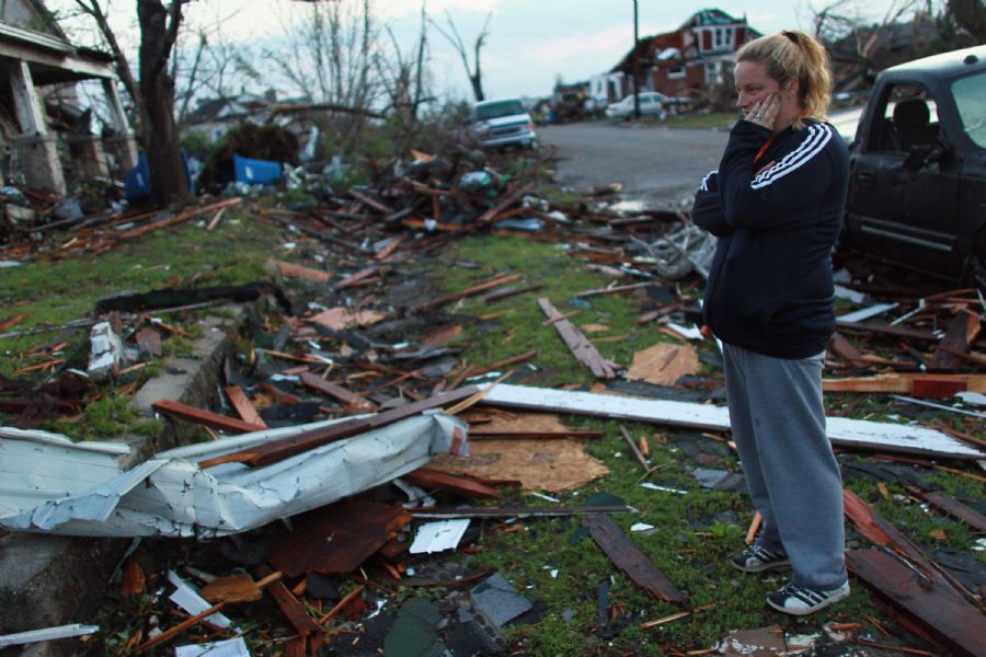 Moradora olha casa destruí­da em Joplin, onde um grande tornado matou ao menos 117 pessoas