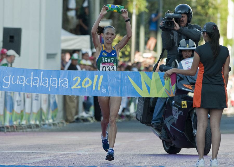 Adriana cruza a linha de chegada com a bandeira do Brasil em mãos: ouro e recorde / Luis Acosta/AFP
