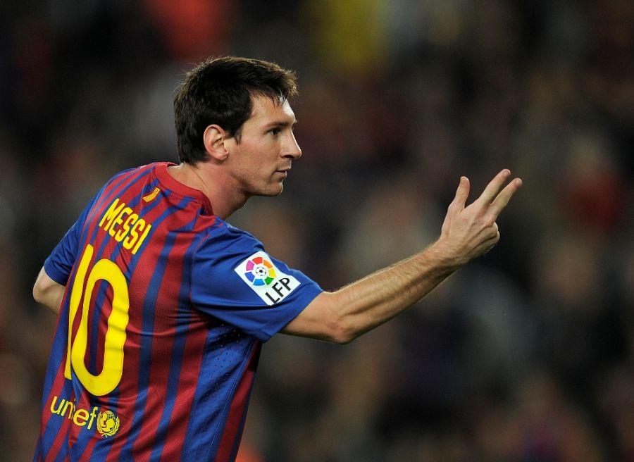 Messi mostra os dedos em alusão aos três gols que marcou para o Barça / Lluis Gene/AFP