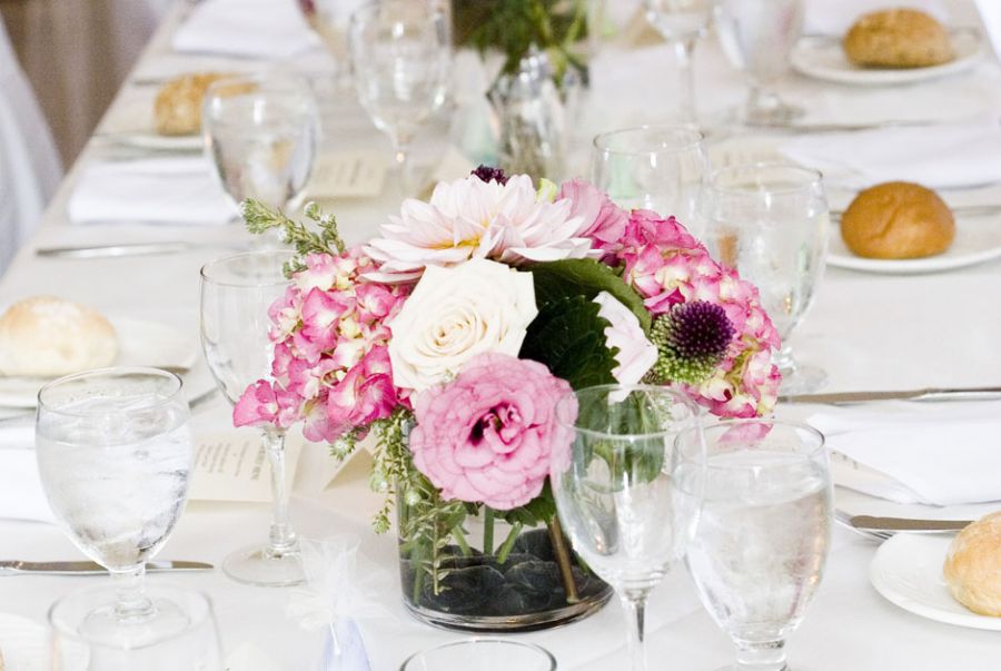 Um enfeite de mesa com flores rosa se destaca na decoração