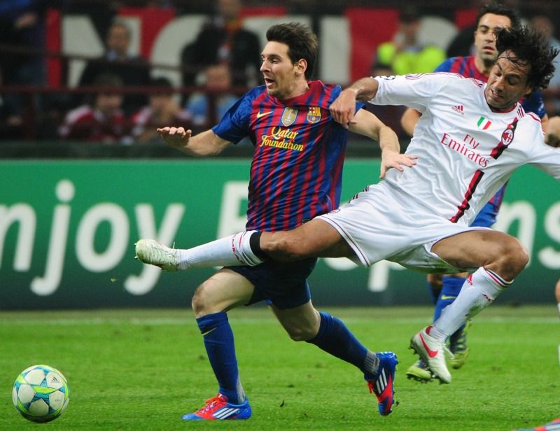 Messi e Iniesta disputam a bola no primeiro jogo realizado no San Siro, em Milão / Andrew Yates/AFP